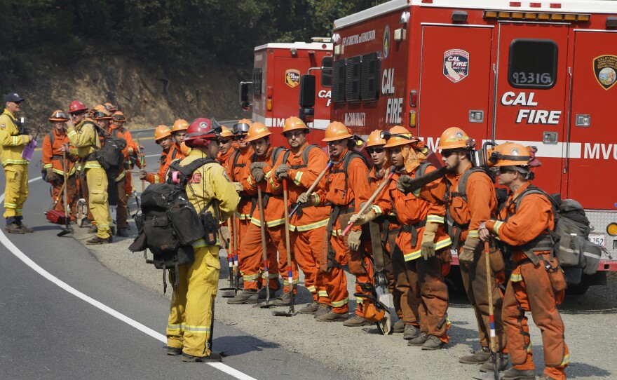 Prisoners from the McCain inmate crew from San Diego prepare to clear brush from a road on Wednesday in Calistoga.