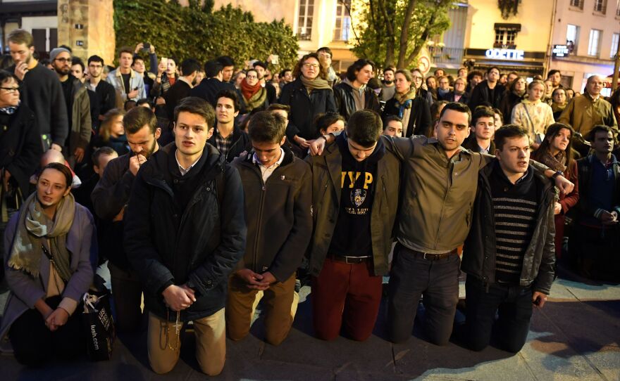 People kneeled in prayer as the flames engulf the Catholic Notre Dame Cathedral on Monday.