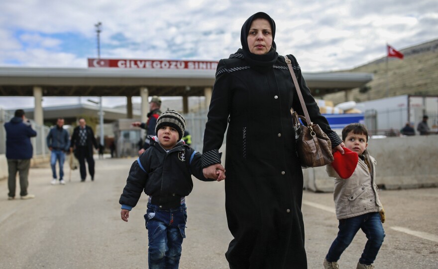 Iptisam Muhammed, 25, from Aleppo, Syria, walks with her children after crossing into Turkey at the Cilvegozu border gate on Sunday. Several people were able to cross into Turkey after they managed to leave the embattled Syrian city.