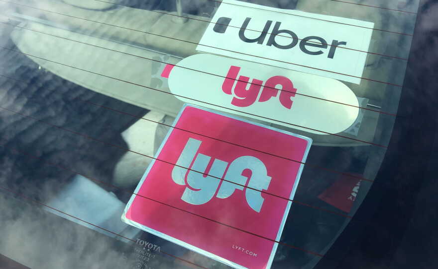 Uber and Lyft stickers are visible in the rear windshield of a car, Nov. 5, 2020.