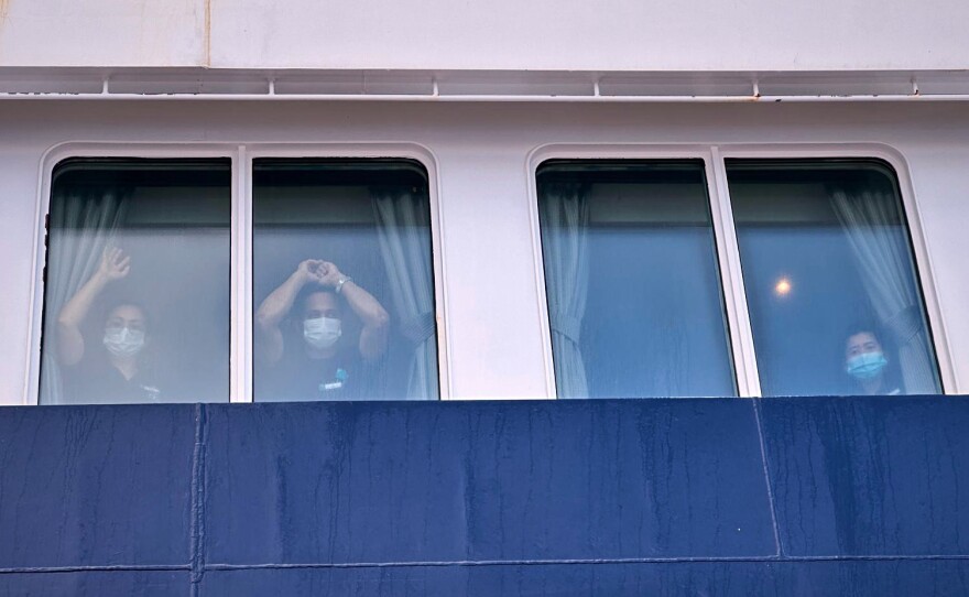 Passengers watch as others are disembarked from the hantavirus-stricken cruise ship MV Hondius at the port of Granadilla in Tenerife, Canary Islands, Spain, Sunday, May 10, 2026.