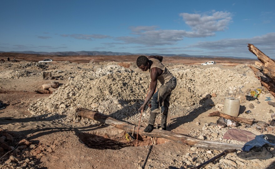 A diamond miner hauls up a bucket of gravel at an illegal mining site in South Africa's Northern Cape Province.