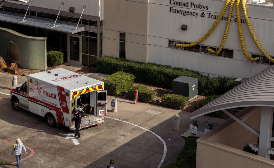 A paramedic waits with a patient in his ambulance outside the Conrad Prebys Emergency Room at Scripps Mercy Hospital in the Hillcrest neighborhood of San Diego at around 10:30 a.m. on Friday January 7, 2022.