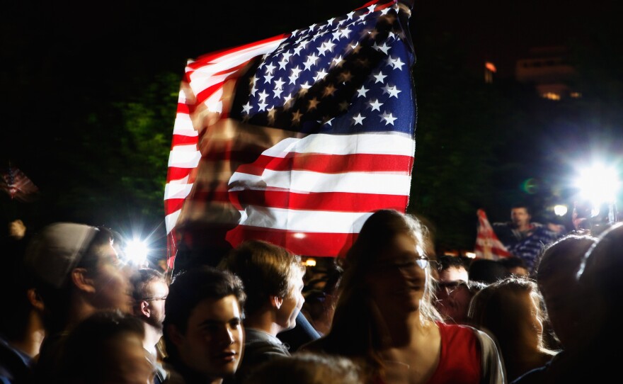 Students gather at the fence on the north side of the White House, pose for photographs, chant 'U.S.A.! U.S.A.!' and sing the Star Spangled Banner while U.S. President Barack Obama announces the death of Osama Bin Laden during a late evening statement to the press in the East Room of the White House May 1, 2011 in Washington, DC.