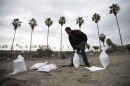 A man fills bags with sand from La Jolla Shores as the San Diego area braces for an approaching storm, Dec. 2, 2014.