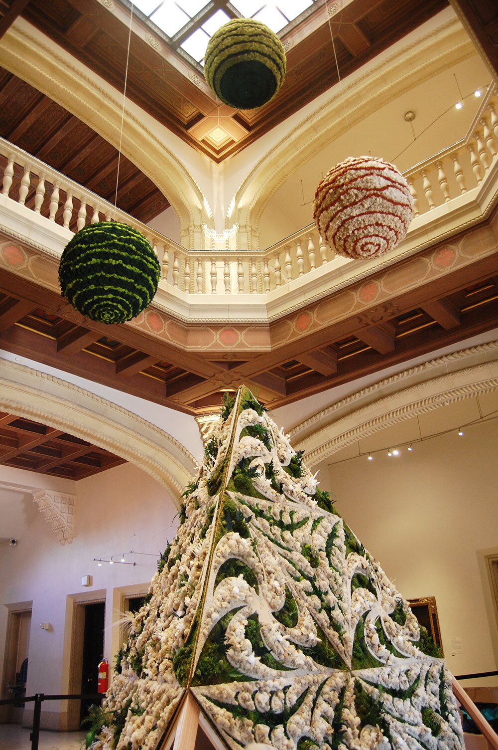 The in-progress installation of Britton Neubacher's "Organized Chaos," a botanical sculpture made of preserved mosses and foliage, wood and more, including three giant disco ball motors, shown in an Apr. 25, 2022 photo in the San Diego Museum of Art rotunda. The finished installation will be on view during Art Alive, Apr. 28 through May 1, 2022.