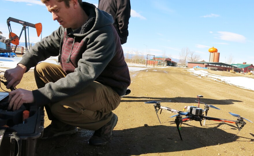 Jimmy Underhill, drone technician with Agribotix, prepares the drone's control module at a farm in rural Weld County.