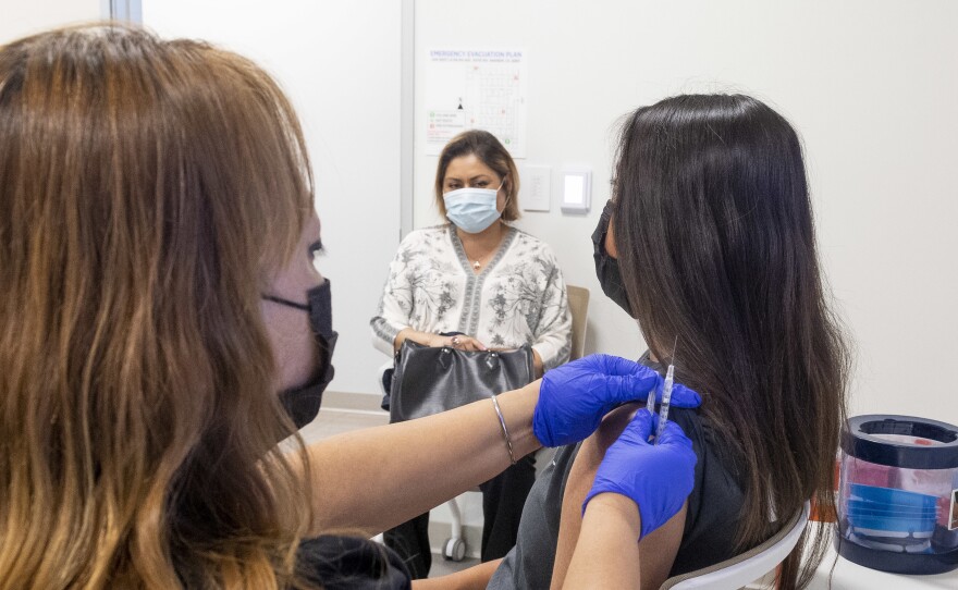 A 16-year-old gets a Pfizer-BioNTech COVID-19 vaccine in Anaheim, Calif., on April 28. Advisers to the Centers for Disease Control and Prevention now say it's not necessary for adolescents to wait two weeks after a COVID shot to receive routine immunizations.