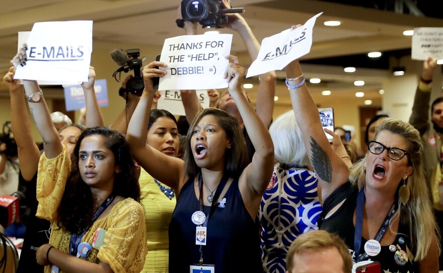 Protesters yell as DNC Chairwoman Debbie Wasserman Schultz, D-Fla., arrives for a Florida delegation breakfast Monday in Philadelphia.