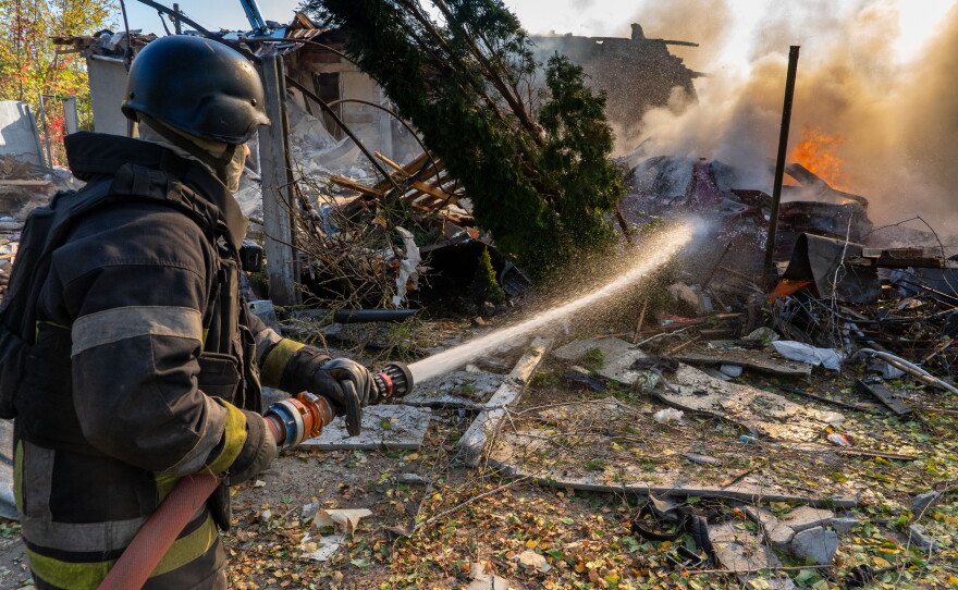 A rescue worker puts out a fire at residential houses destroyed in a Russian strike on Kharkiv, Ukraine, Sunday, Oct. 11, 2026.