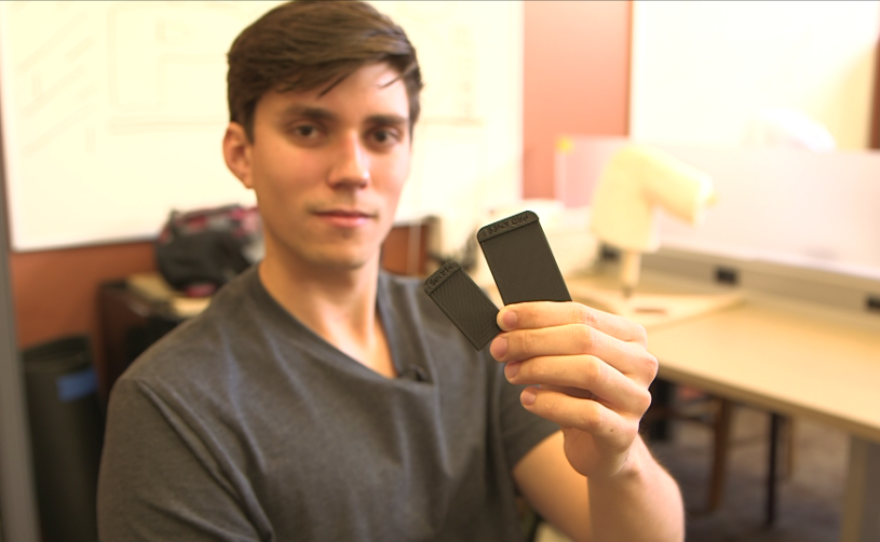 SDSU engineering student Spencer Koroly holds up rectangular plastic parts of his kneepad prototype, made from a 3-D printer.