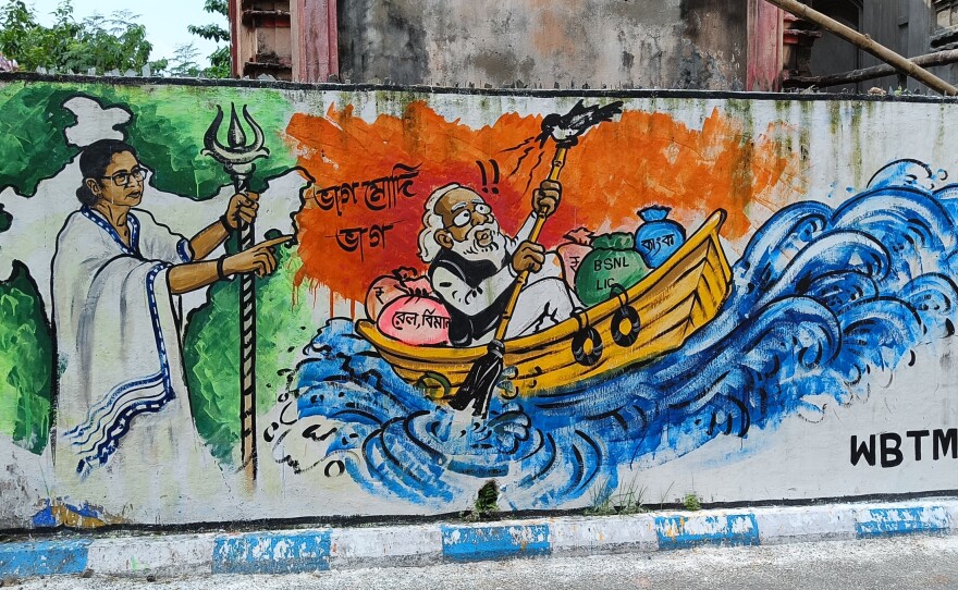 Graffiti depicts Mamata Banerjee, the chief minister of West Bengal, as "Mother India" banishing Prime Minister Narendra Modi into the Bay of Bengal.