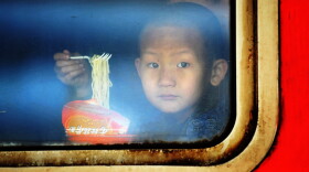 A child eats instant noodles on a train at the Harbin Railway Station in northeast China.
