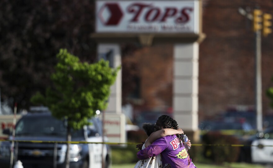 People hug outside the scene after a shooting at a supermarket on May 14, 2022, in Buffalo, N.Y.