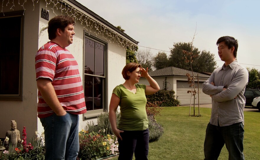 Tom Xia (right) visits his neighbors Evelyn and Tim Jones.