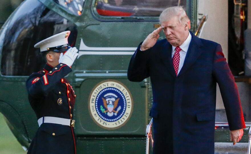 President Trump salutes as he disembarks Marine One on the South Lawn of the White House on Sunday. Trump signed a new executive order on travel and refugee resettlement on Monday.