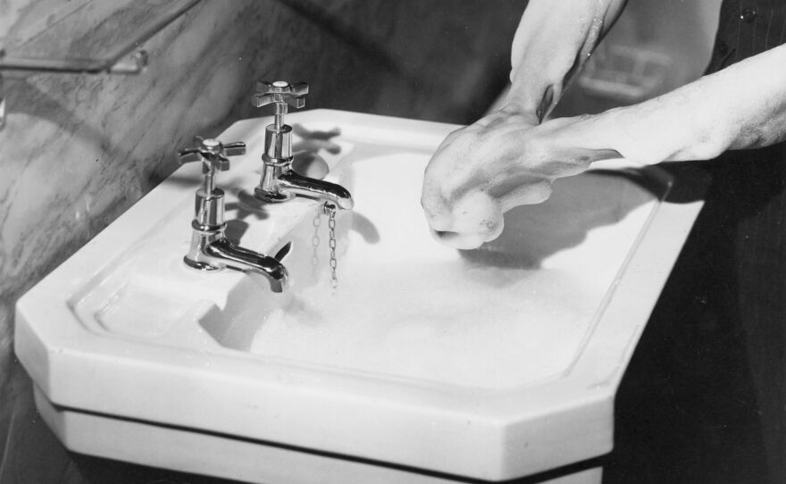 Washing hands in a sink in 1937