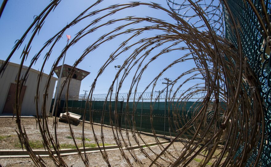 In this photo reviewed by U.S. military officials, the control tower is seen through the razor wire inside the Camp VI detention facility, Wednesday, April 17, 2019, in Guantanamo Bay Naval Base, Cuba.