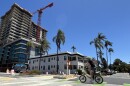 A cyclist rides by the construction site of a high-rise apartment building in Banker's Hill, July 25, 2025.