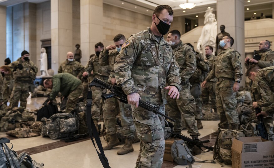 Hundreds of National Guard troops hold inside the Capitol Visitor's Center to reinforce security at the Capitol in Washington on Wednesday. It comes a week after an insurrection at the Capitol and as the House of Representatives is pursuing an article of impeachment against President Donald Trump for his role in inciting an angry mob to storm the capitol complex.