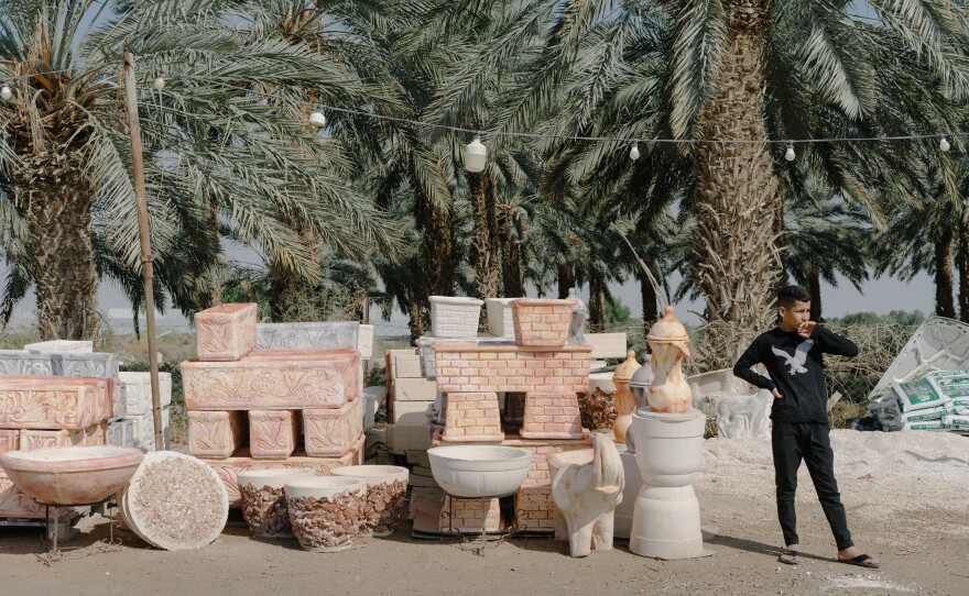 A Palestinian child sells planters and pottery along the road approaching the Dead Sea in the Israeli-occupied West Bank.