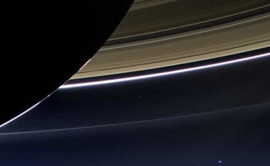 An image taken on July 19, 2013, by the wide-angle camera on NASA's Cassini spacecraft captured Saturn, its rings and planet Earth, which is the tiny dot in the lower right.