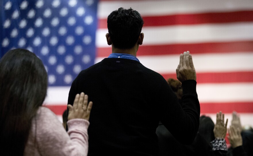 People take the oath of allegiance to become U.S. citizens during a naturalization ceremony at the Los Angeles Convention Center in 2017.