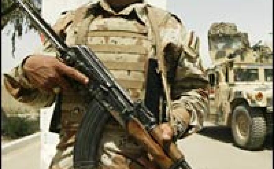 An Iraqi soldier mans a checkpoint in the restive Baghdad neighborhood of Yarmuk, May 7, 2007. Security milestones are among the benchmarks under discussion for Iraq.
