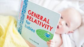 Milo Faust, 1, looks at a book from the <em>Baby University</em> series.