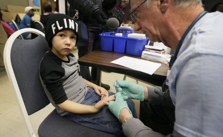 Registered Nurse Brian Jones draws a blood sample from Grayling Stefek, 5, at the Eisenhower Elementary School in Flint in January. The students were being tested for lead after elevated levels were found in the city's drinking water.