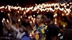 Veronica Hartfield, stands with her son, Ayzayah Hartfield during a candlelight vigil for her husband, Las Vegas police officer Charleston Hartfield, Thursday, Oct. 5, 2017, in Las Vegas. 