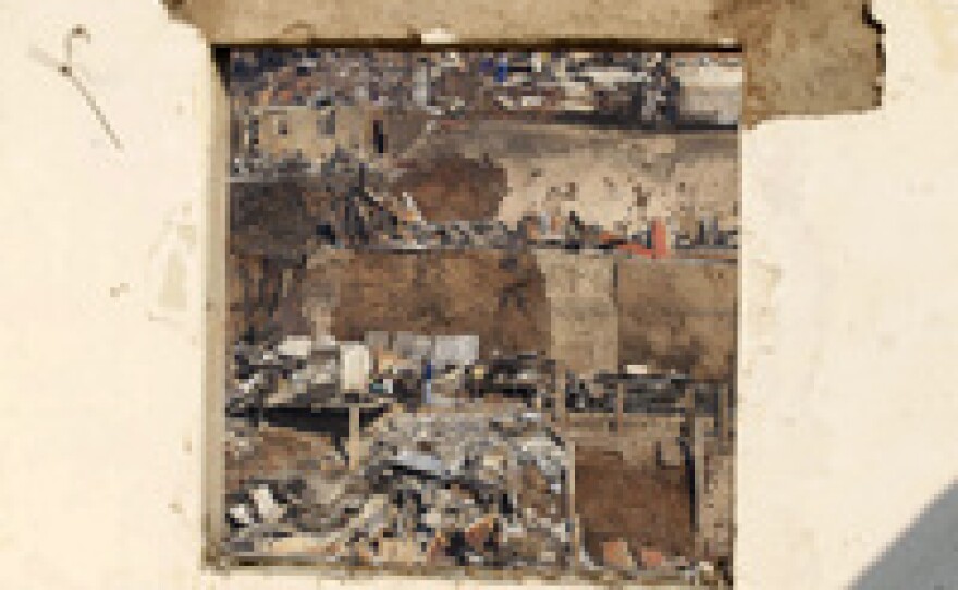 Residents are seen through a window as they survey the damage after a wildfire burned homes in Valparaiso, northwest of Santiago, Sunday.