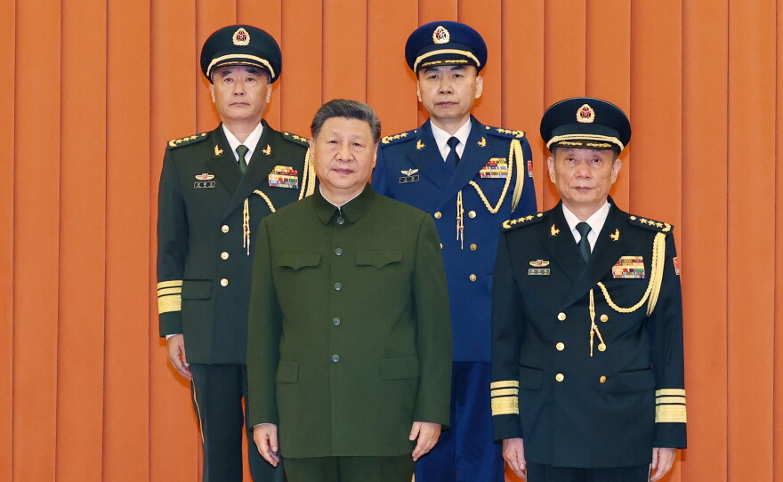 In this photo released by Xinhua News Agency, Chinese President Xi Jinping, bottom left, who is also Chairman of the Central Military Commission (CMC) poses for photos with newly promoted generals Wang Shuguang, top left and Wang Gang, top right while Zhang Shengmin, Vice Chairman of the CMC stands at the right in Beijing, on Friday, July 3, 2026.