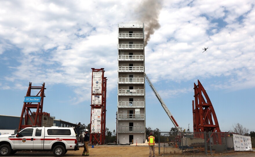 Smoke rises out of the ninth story of a cold-formed steel building on UC San Diego's shake table on Thursday, July 17, 2025.