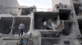 An Emirates aircraft prepares for landing as a smoke plume rises from an ongoing fire near Dubai International Airport in Dubai, United Arab Emirates, on Monday.