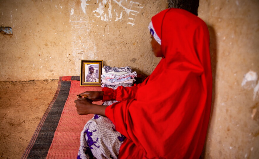 Fatima Ibrahim sits alongside a portrait of her son, Abdullahi, in the family's one-room home in Sabon Gari, Nigeria.