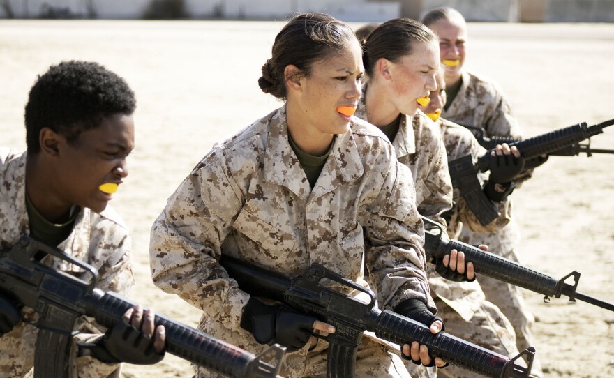 Female Marine recruits brandish rifles during the confidence course of their basic training, March 9, 2021.