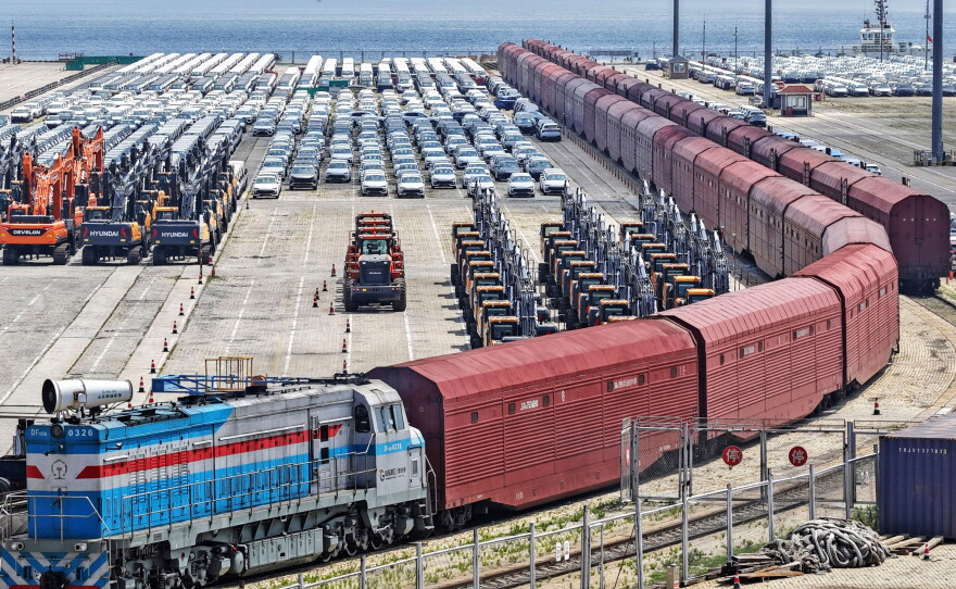 Heavy equipment and cars are prepared for shipment by rail in Yantai, eastern China's Shandong province, on June 20, 2026.