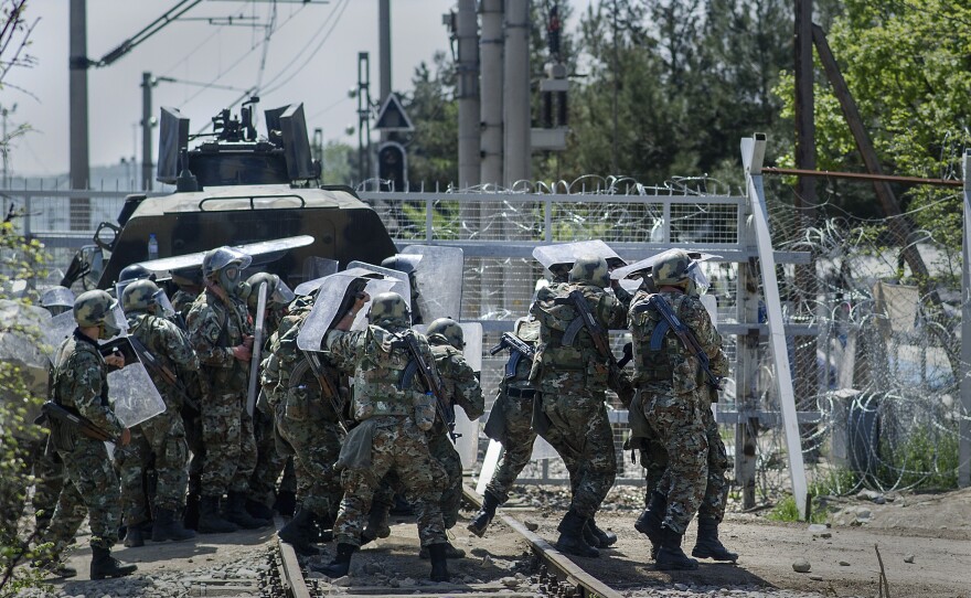 Macedonian police react as migrants and refugees throw stones during clashes at the border Sunday.