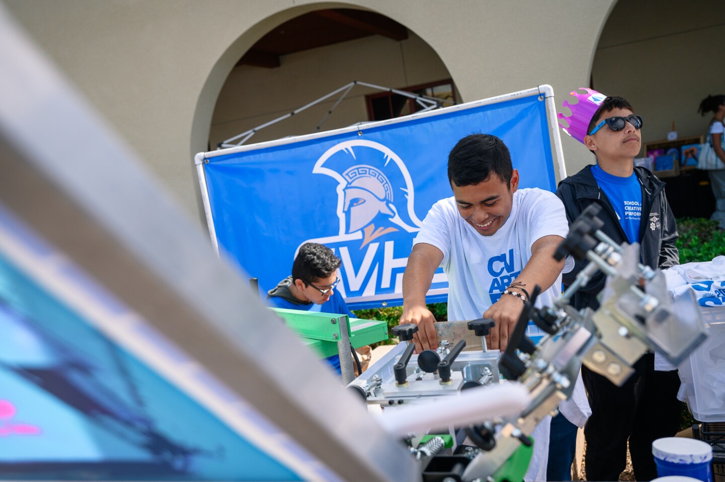 Chula Vista High students laugh while operating a screen printer at the inaugural Chula Vista Art Fest, outside Chula Vista City Hall, on Sept. 30, 2023.