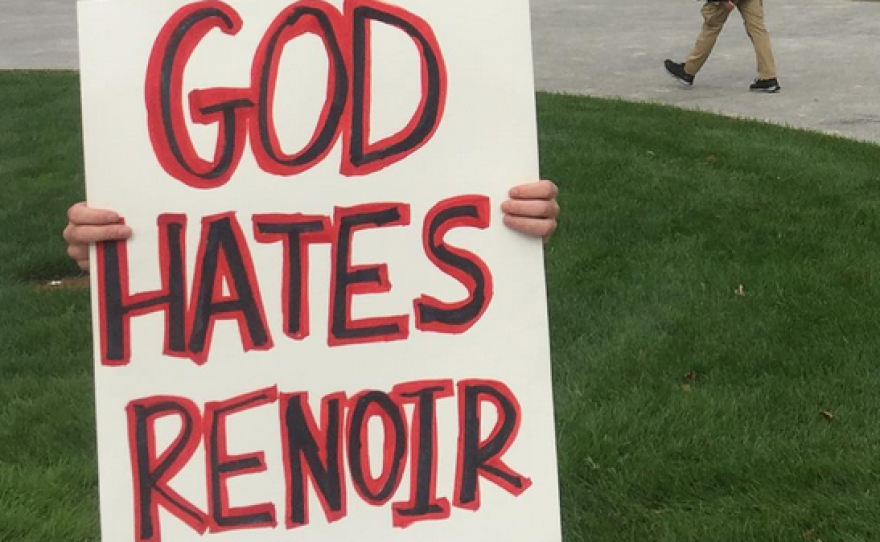 A protester holds a sign outside of the Boston Museum of Fine Arts on Monday.