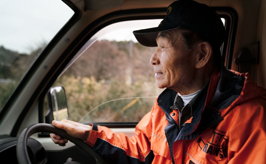 Kanno drives his truck down a main road in his neighborhood, chasing monkeys that he saw scampering around his house not long ago.