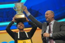 E.W. Scripps Company president and CEO Adam Symson holds the trophy over Shrey Parikh, winner of the 2026 Scripps National Spelling Bee, at DAR Constitution Hall in Washington, D.C. on Thursday.