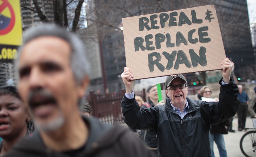 Demonstrators gather near Trump Tower after the defeat of the GOP health care plan. One man holds up a sign, urging the ouster of House Speaker Paul Ryan, who spearheaded the failed effort.