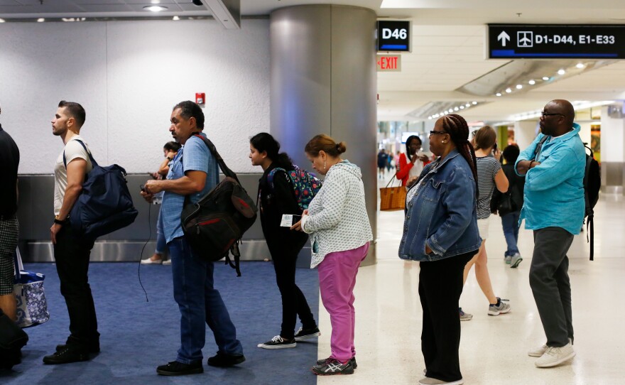 Deilanis Santana, 13, and her great aunt, Lillian Mercado, begin to board their flight from Miami to Hartford, Conn.