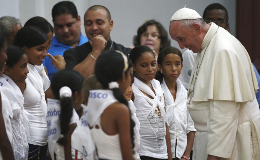 Pope Francis talks with a group of children in the sanctuary of the Virgin of Charity of Cobre, in El Cobre, Cuba, Monday, Sept. 21, 2015.
