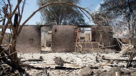 A burned out residence stands amid rubble on Highway 138 after the Blue Cut fire burned through Phelan, Aug. 18, 2016.