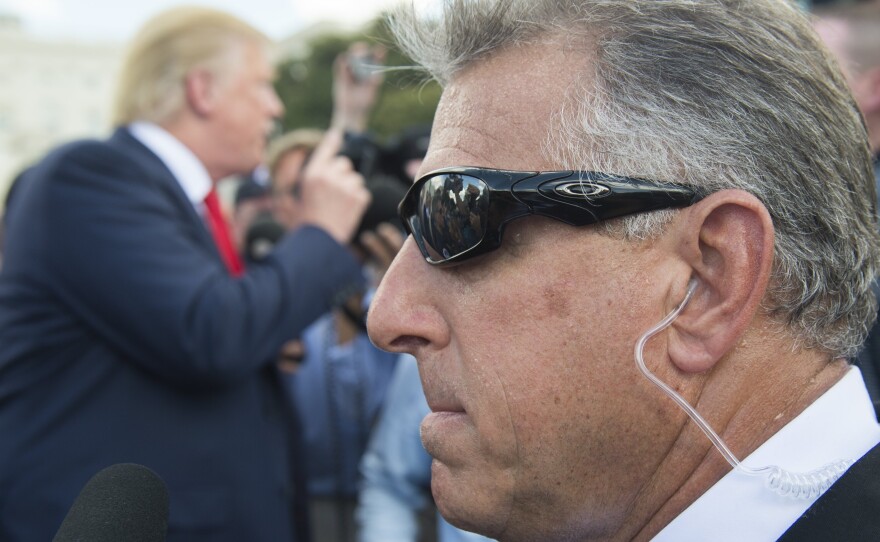 A member of Donald Trump's private security team stands watch as Trump speaks to reporters in September.