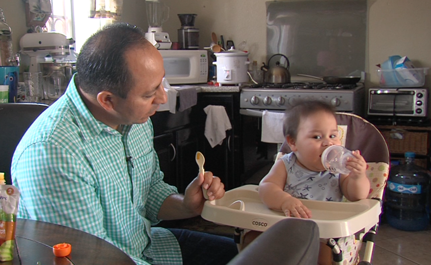 Eduardo Bohorquez feeds his son, July 27, 2016.