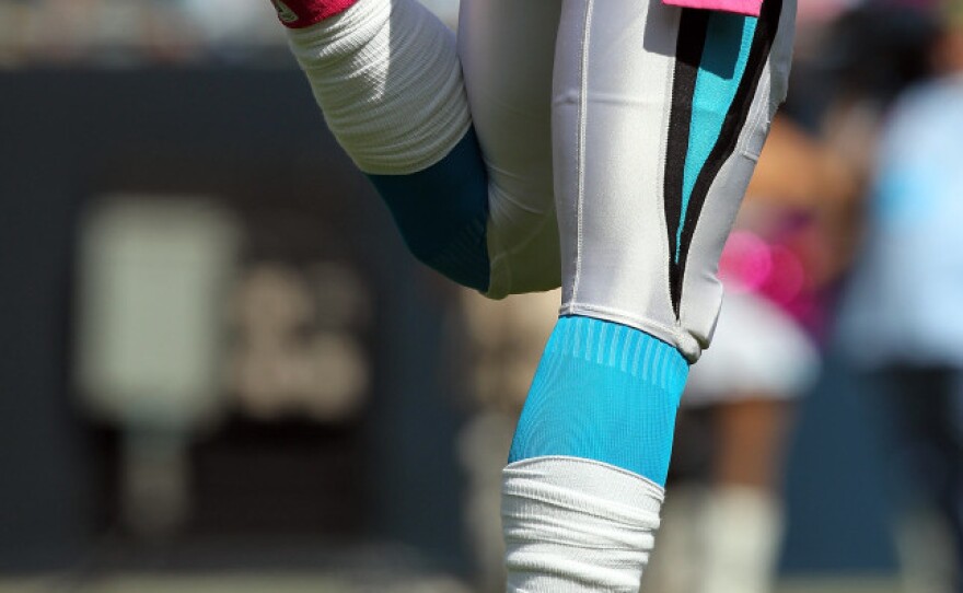 <p>Cam Newton #1 of the Carolina Panthers stretching as he wears pink for breast cancer awareness during their game at Bank of America Stadium in October.</p>